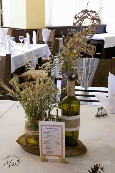 Аранжировка за маса за рустик сватба с дървено пънче, ваза със полски цветя и свещник